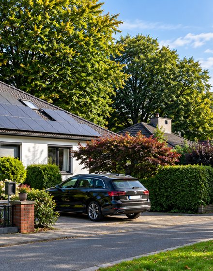 Wohnhaus mit Photovoltaik-Anlage und Auto in der Einfahrt