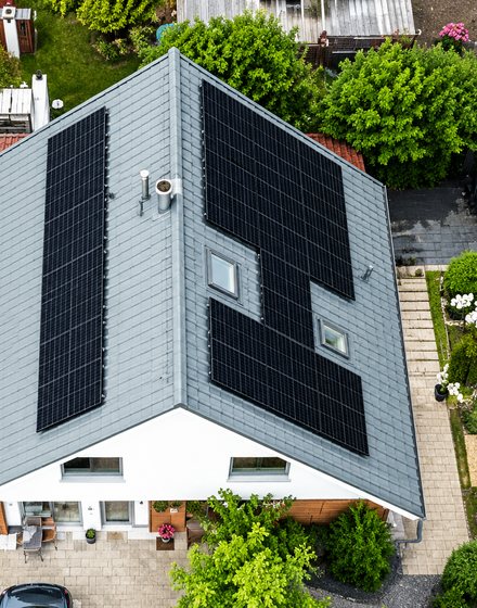 Luftaufnahme eines Hausdachs mit Photovoltaik-Modulen